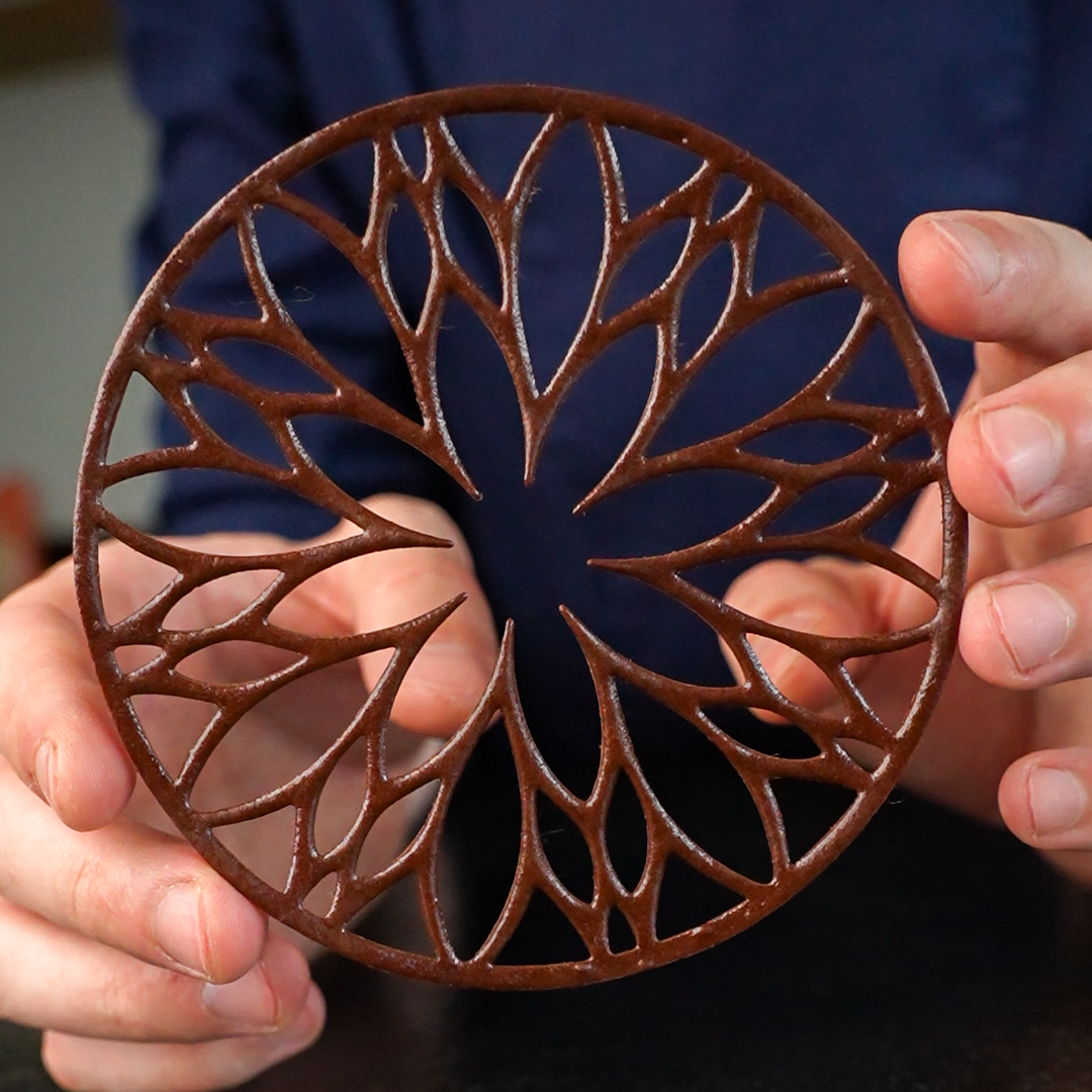 Elegant chocolate tuile made with the Florentis silicone mold held delicately in hand – showcasing fine texture and craftsmanship for gourmet dessert decoration.