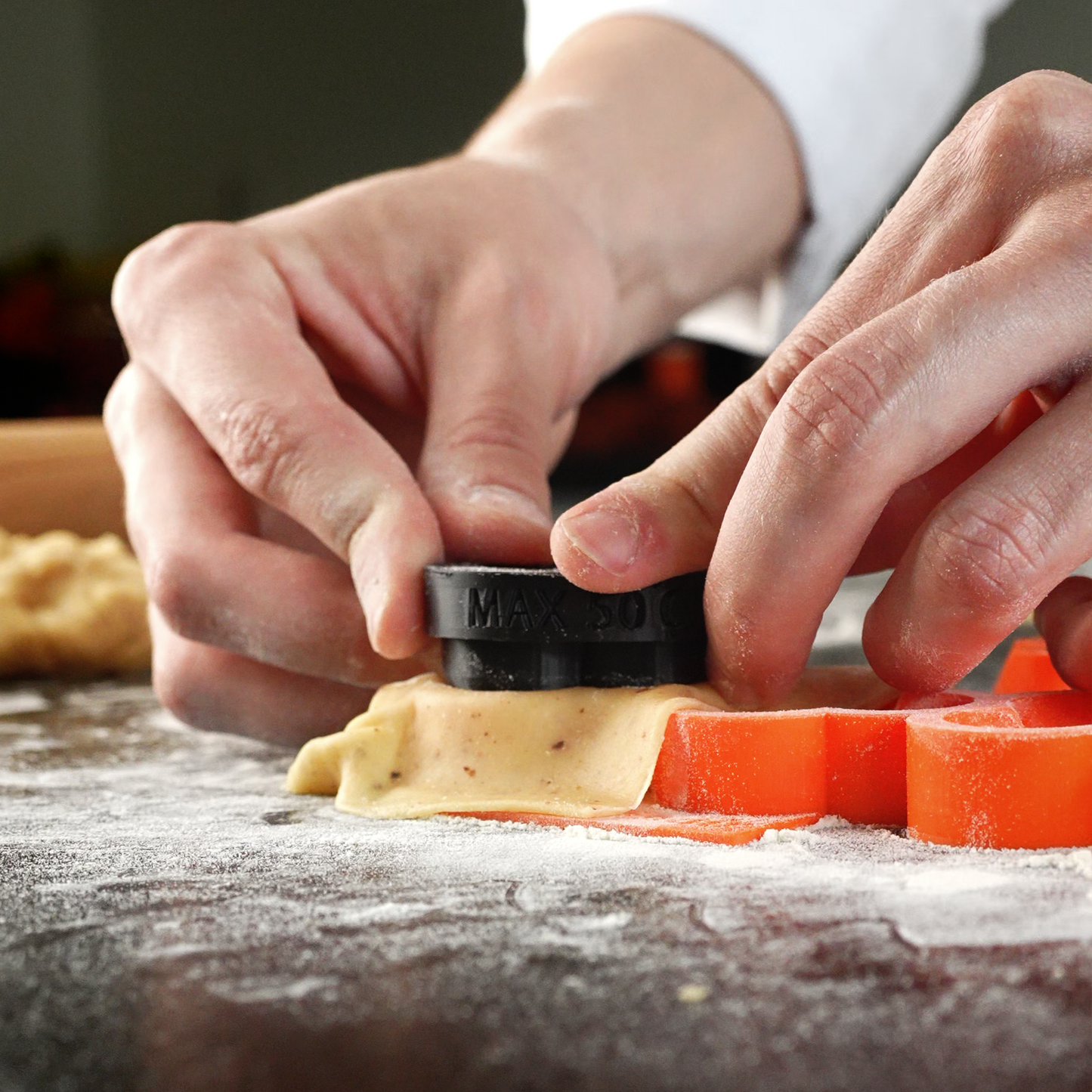 Close up action photo of a tartelette cutter from a different angle, showing precise cutting for perfect pastry shells in professional baking.