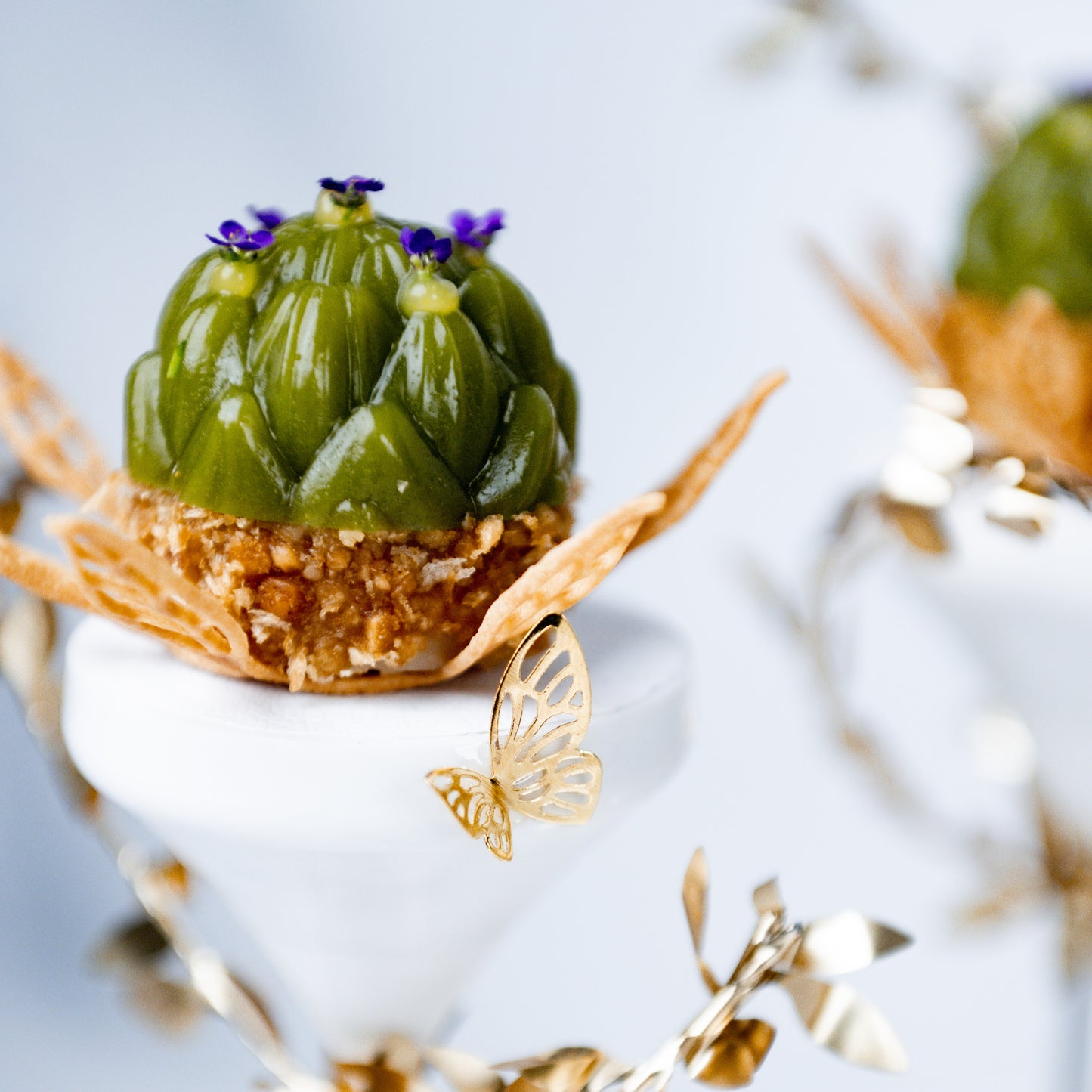 Artichoke dish created by Bocuse d’Or Netherlands, presented on a pillar with gold leaf decoration for fine dining presentation.