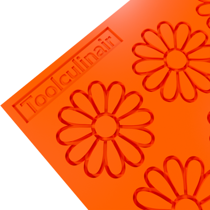 Close-up angled 3D render of an orange Toolculinair chamomile silicone tuile mold showing the flower-shaped cavity detail, with visible Toolculinair logo on the mold surface.