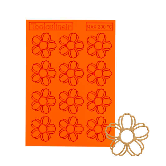 3D render of an orange Toolculinair silicone tuile mold with visible logo, showing a cherry blossom-shaped tuile cavity in the bottom right area of the mold.