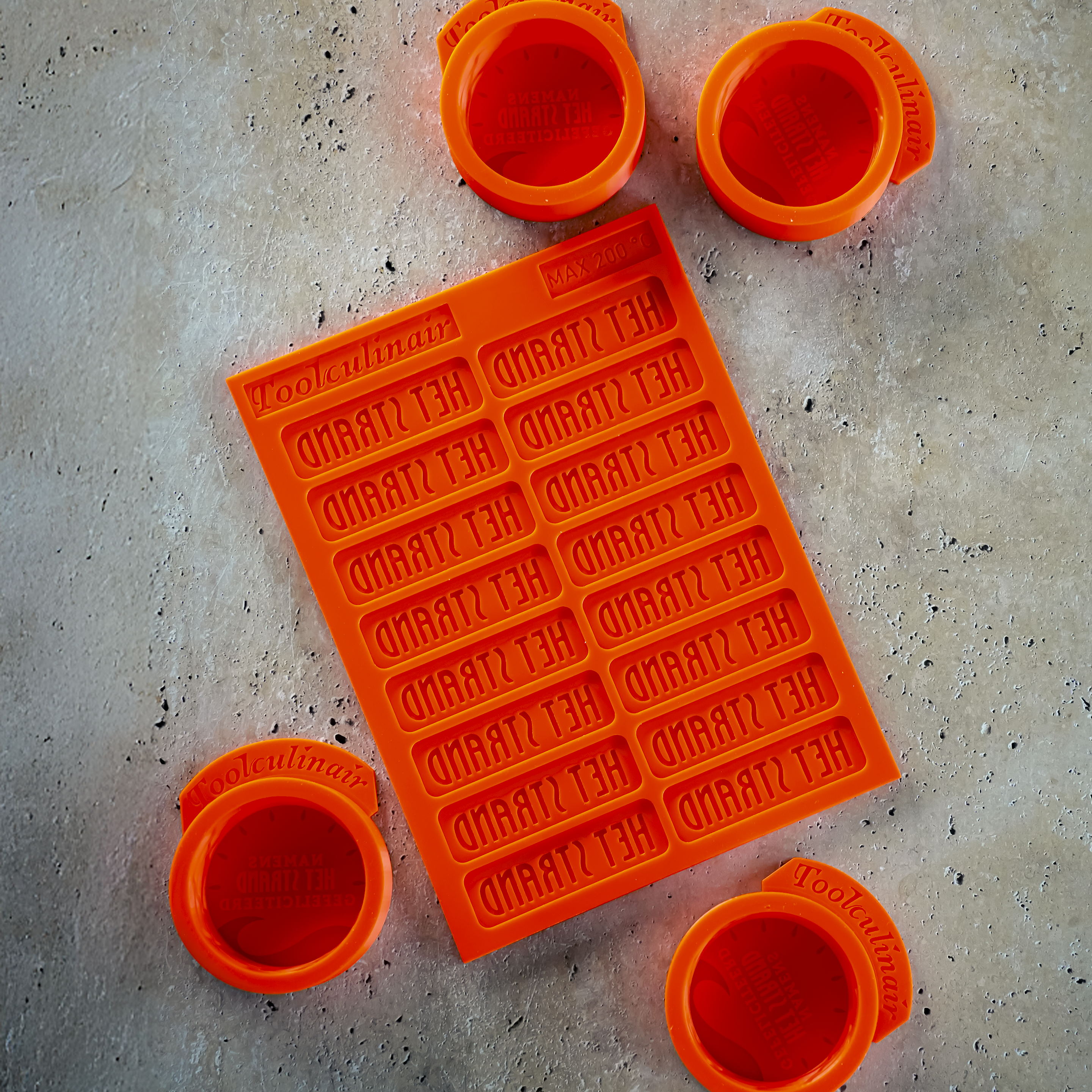 Custom silicone molds made by Toolculinair for restaurant Het Strand, showcasing one tuile mold and three 3D molds with the restaurant’s logo – ideal for professional use in creative and refined dish presentation.
