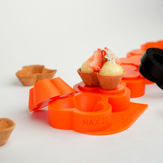Photo of the Flora food safe silicone tartelette mold with a small tartlet example, showcasing the mold’s detail and suitability for creating delicate sweet and savory pastries.