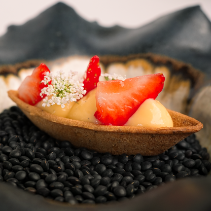 Photo of a tartlette made with the Sculptura food safe silicone mold, filled with pastry cream, fresh strawberries, and garnished with fine dining edible flowers, showcasing an elegant dessert presentation.