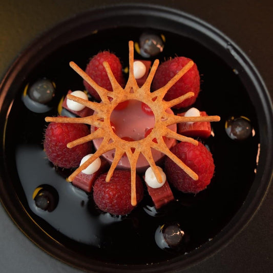 The Solar tuile cookie artistically arranged on a plate, featuring its radiant sunburst design to complement the dish with a bright touch